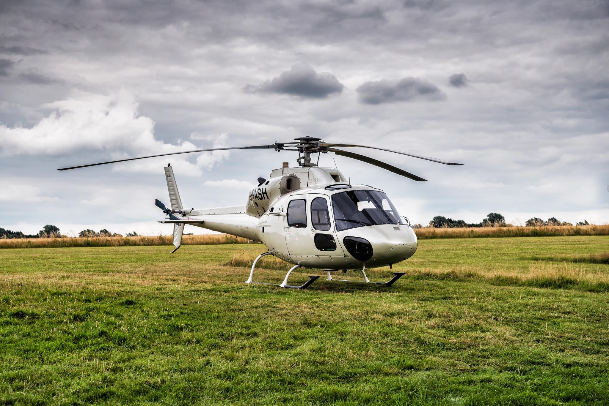 An aerial adventure captured by Wright Content, featuring a helicopter standing in a field on the outskirts of London. This image represents the start of an epic aerial photography journey over the city of London. Wright Content specializes in capturing stunning aerial perspectives of urban landscapes.