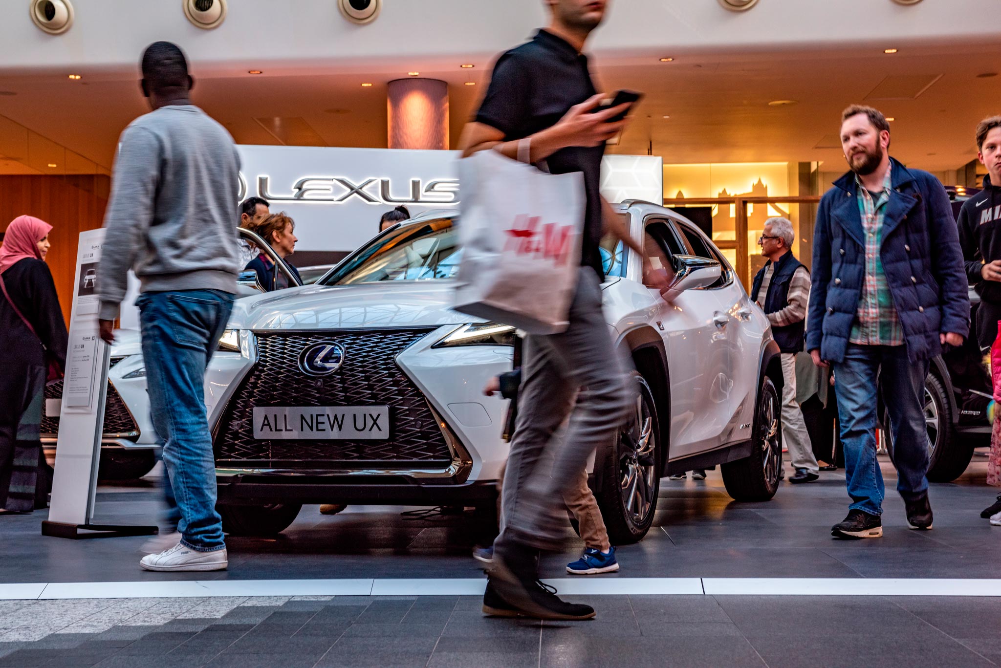 A dynamic scene captured by Wright Content, showcasing shoppers passing by a Lexus car at its event in Westfield Shopping Centre, London. This long shutter speed shot encapsulates the energy and movement of the experiential marketing campaign. Wright Content excels in documenting impactful marketing experiences.