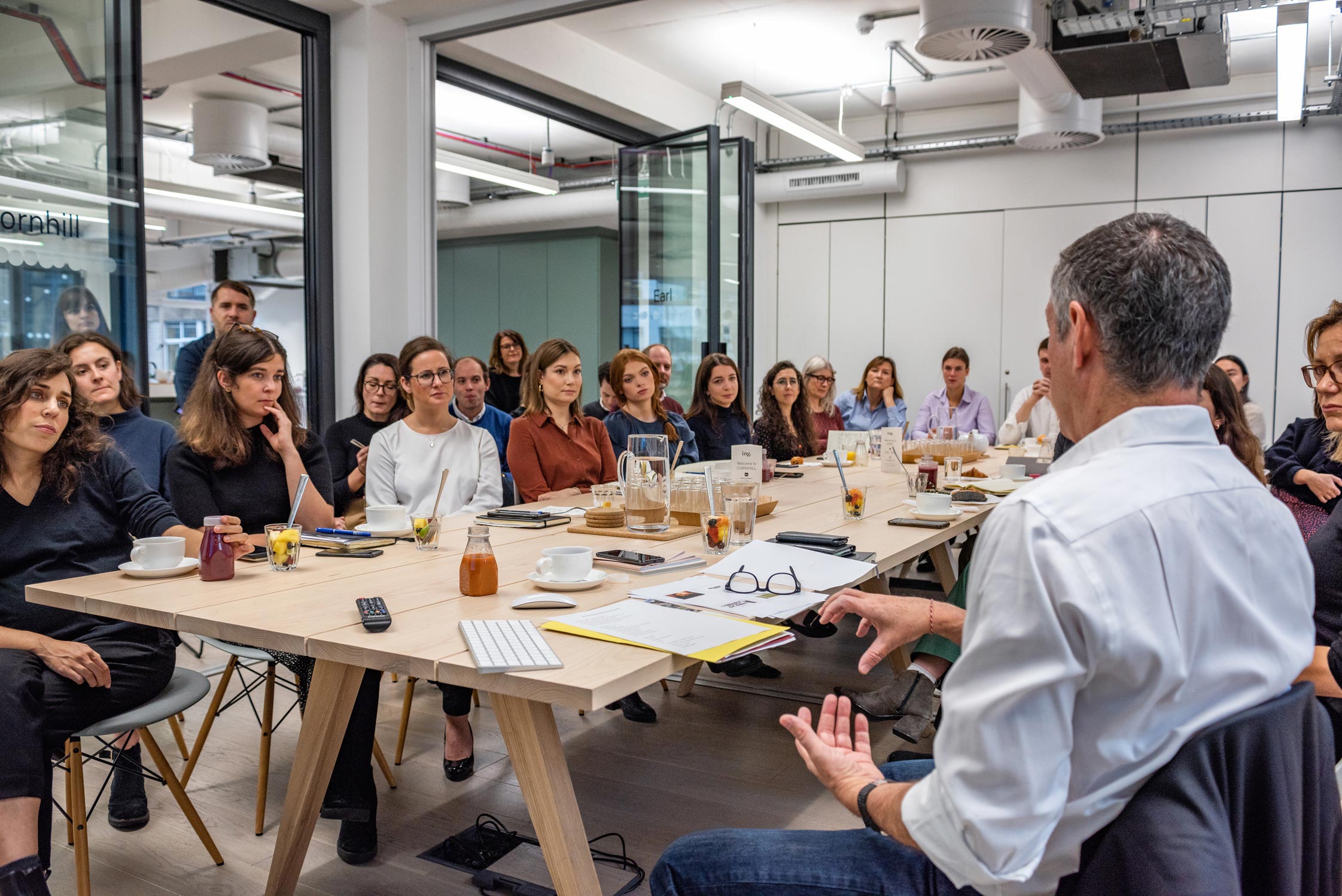 A different angle captures Moray MacLennan from M&C Saatchi Group giving a talk to professionals in a boardroom in Central London. Faces of the attentive audience are visible as they listen intently, captured in reportage style by Wright Content.