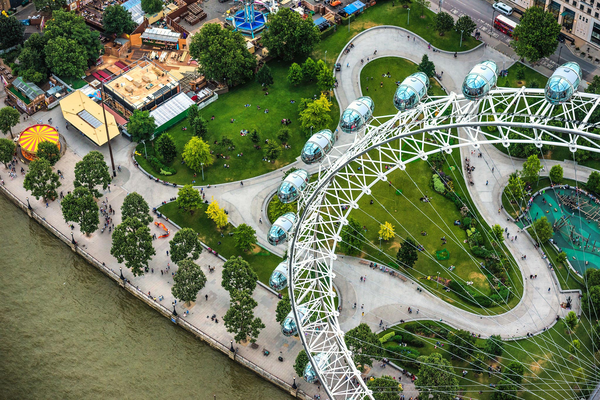 Aerial photograph of the London Eye captured by Wright Content from a helicopter. The camera looks down onto the iconic landmark, offering a unique perspective of the attraction and its surrounding parks on the South Bank.