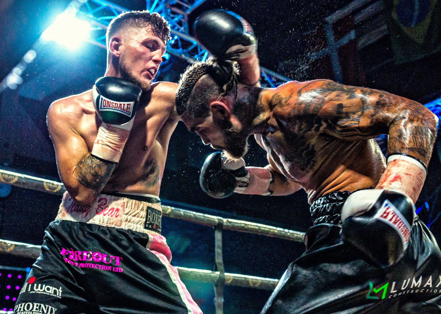 A captivating shot from ringside at a professional boxing match, captured by Wright Content, your premier boxing photographer in London. The image depicts a boxer delivering a jab while another boxer ducks and launches an uppercut, frozen in time as droplets of water fly through the air, adding to the intensity of the moment.