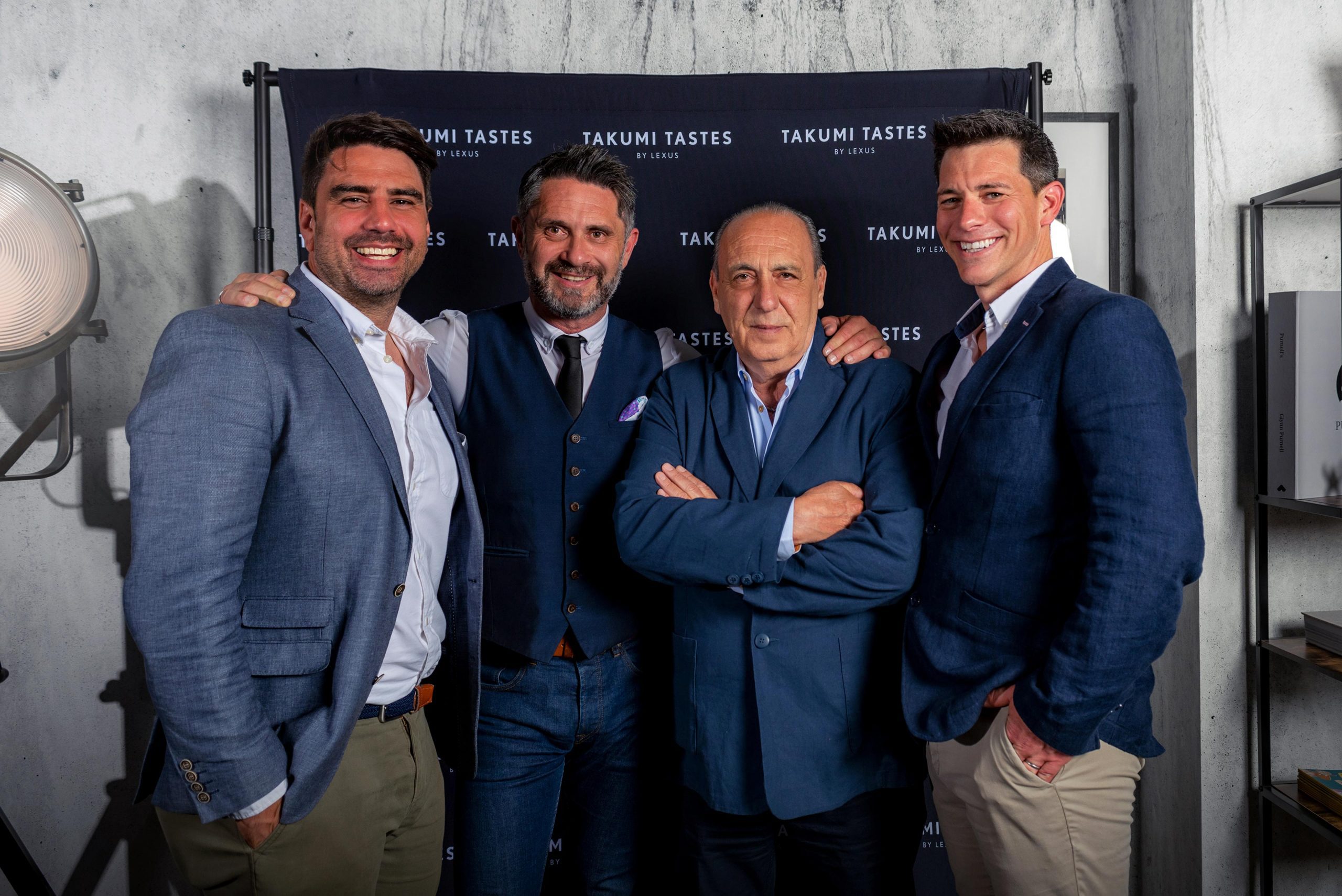 Group of renowned celebrity chefs smiling and posing for the camera at an exclusive event.