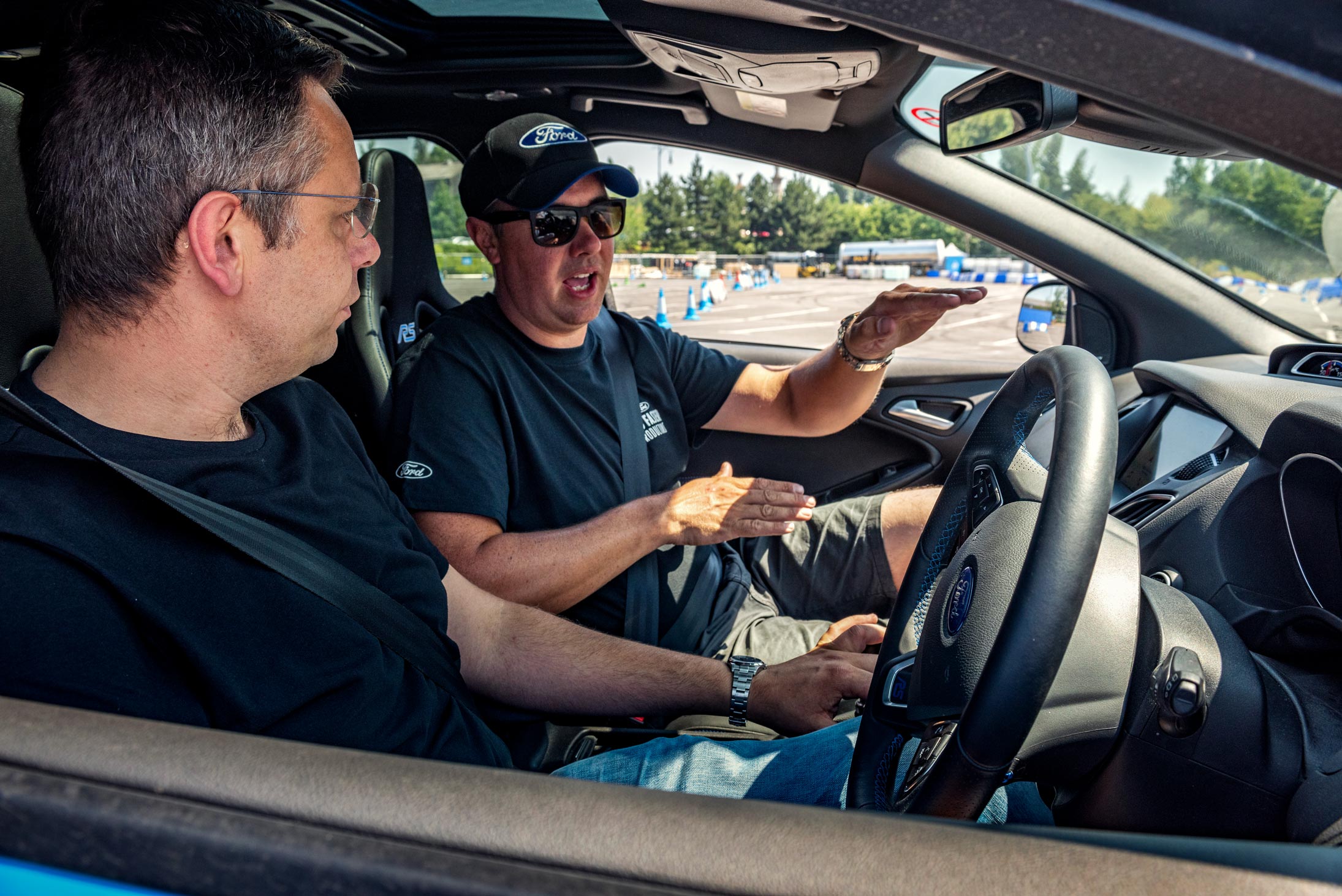 An adrenaline-fueled moment captured by Wright Content, featuring a professional driver instructing a journalist on how to perform donuts in a sports car. Inside the car, the journalist receives expert guidance as they prepare to unleash the thrill of drifting. Wright Content specializes in dynamic motorsport event photography.