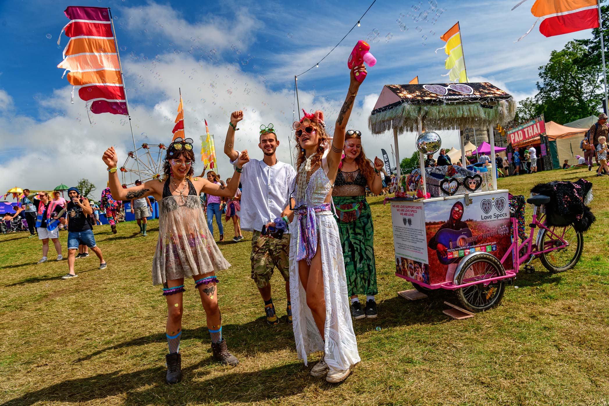 oin the vibrant celebration at a music festival captured by Wright Content during the daytime. In this lively shot, festival-goers immerse themselves in the festive atmosphere, joyfully blowing bubbles high into the sky. Adorned in colorful festival attire, they radiate excitement and happiness under the sun. Wright Content's expert photography encapsulates the exuberance of daytime festival revelry